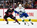 Liam Ohgren handles the puck against Dylan Cozens of the Ottawa Senators during a game in January.