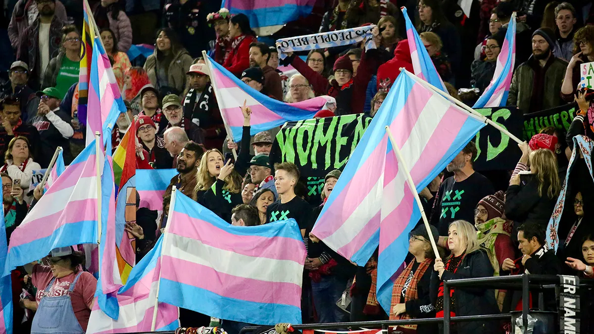 Save Women's Sports activists are surrounded by an agitated group of trans supporters after a big